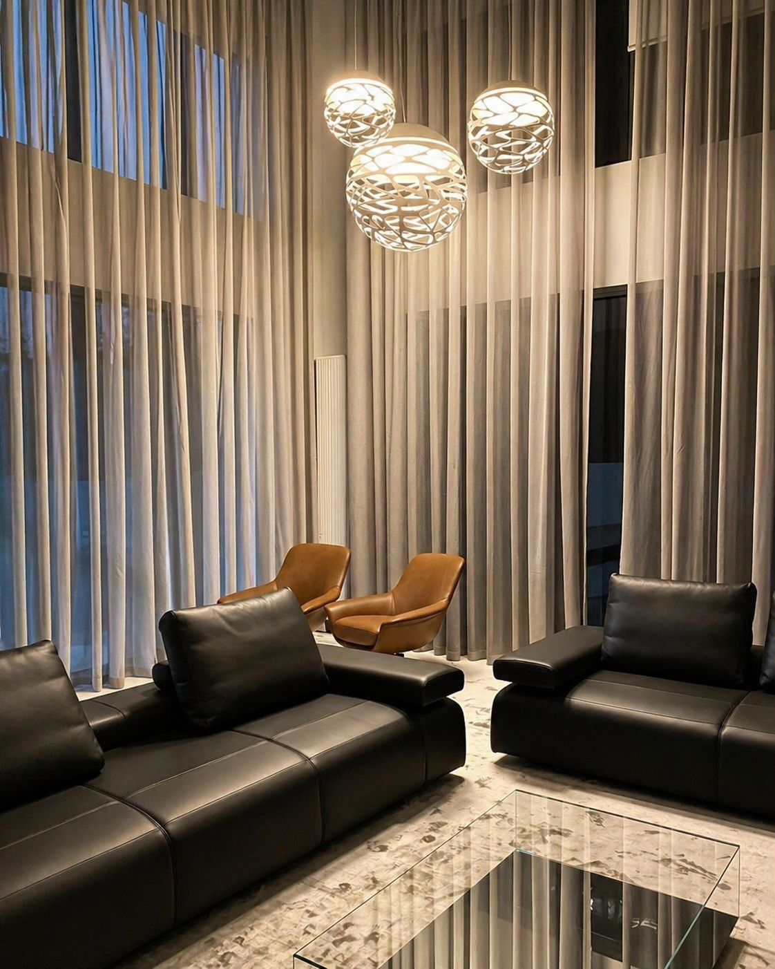 Architectural interior with sheer curtains and floor-to-ceiling windows